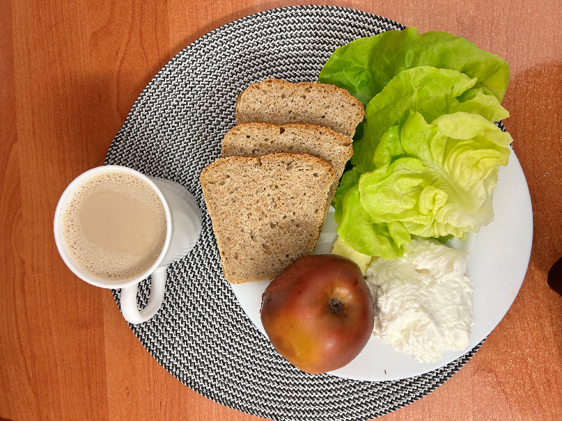 Na zdjęciu: Kawa z mlekiem, Chleb Graham, Masło extra 82%, Serek homo. naturalny, Jabłko pieczone, Sałata zielona
